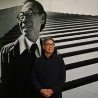 Sandi Pei, son of renowned Chinese-American architect I.M. Pei, poses in front of a photo of his father at a new exhibit at Hong Kong's M+ museum