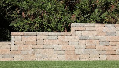 Our neighbors' landscaping is causing our block wall to collapse. What can we do?