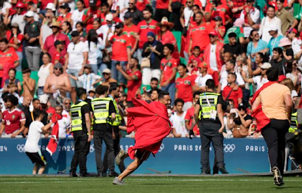 Morocco fans rush field during Olympic soccer opener vs Argentina. Game suspended, goal disallowed