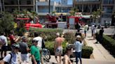 Tourists pose for pictures outside collapsed Majorca beach club
