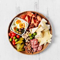 This board typically features a variety of cured meats, such as prosciutto, salami, and chorizo, along with a selection of cheeses, like brie, cheddar, and gouda. Additions may include olives, nuts, dried fruits, and some crusty bread or crackers.