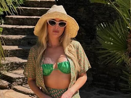 Emma Roberts flashes her tummy in a green bikini top