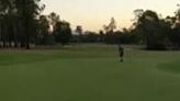 man sinks a 20 foot putt with the help of his friend kicking it in