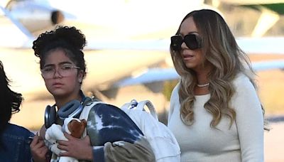 Mariah Carey teases a hint of her tummy in a beige top and maxi skirt