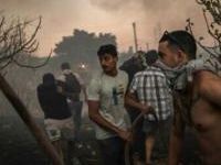 Volunteers try to extinguish a wildfire northeast of Athens that has forced the evacuation of thousands of people in suburban towns