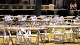 USC graduates walk by vacant chairs and tables in Alumni Park on the USC campus, where the school’ s canceled main stage commencement usually takes place.