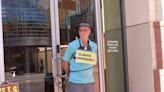 A grandfather politely ties himself to a bank door to protest fossil fuel investments