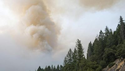 Crews battle wildfires across the US West and fight to hold containment lines