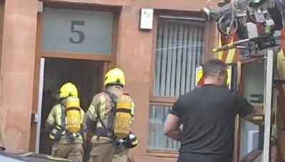 Fire crews battle Uddingston blaze as smoke seen billowing from top flat window