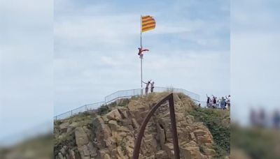 Un hombre intenta arrancar una bandera de Cataluña para sustituirla por una de España