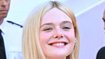 Elle Fanning flashes sideboob in a plunging caped gown