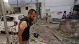 Palestinians inspect the aftermath of an Israeli strike on a building in Gaza's Nuseirat