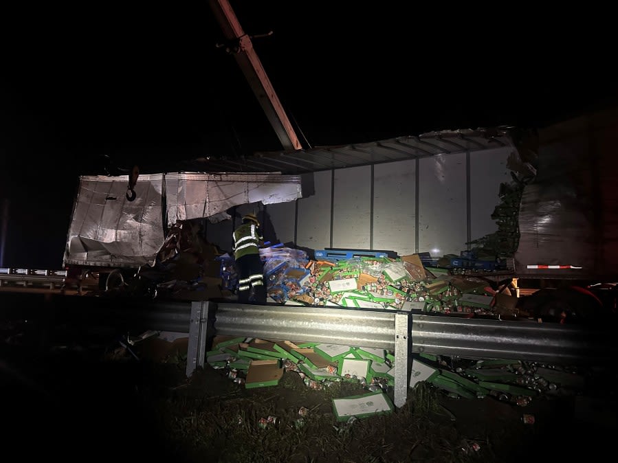 PHOTOS: Semi-truck carrying sausages and sauce flips, spills onto roadway near I-75