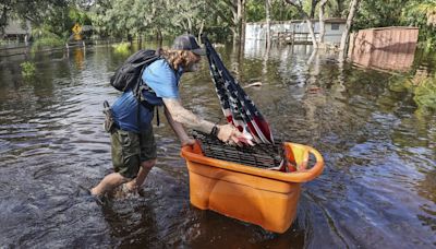 Residents slog through flooded streets, clear debris after Hurricane Milton tore through Florida