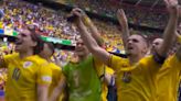 Romania stars lead chants with a megaphone after beating Ukraine