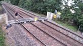 Young boy plays on train tracks while dad chats on mobile phone