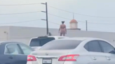 Police confront nude woman standing atop SUV on busy L.A. freeway