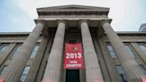 Mayor Craig Greenberg hangs banner honoring 2013 Louisville basketball team at Metro Hall
