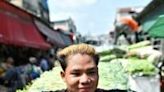 A vendor sweats as he pulls a vegetable cart at Khlong Toei Market in Bangkok on Thursday