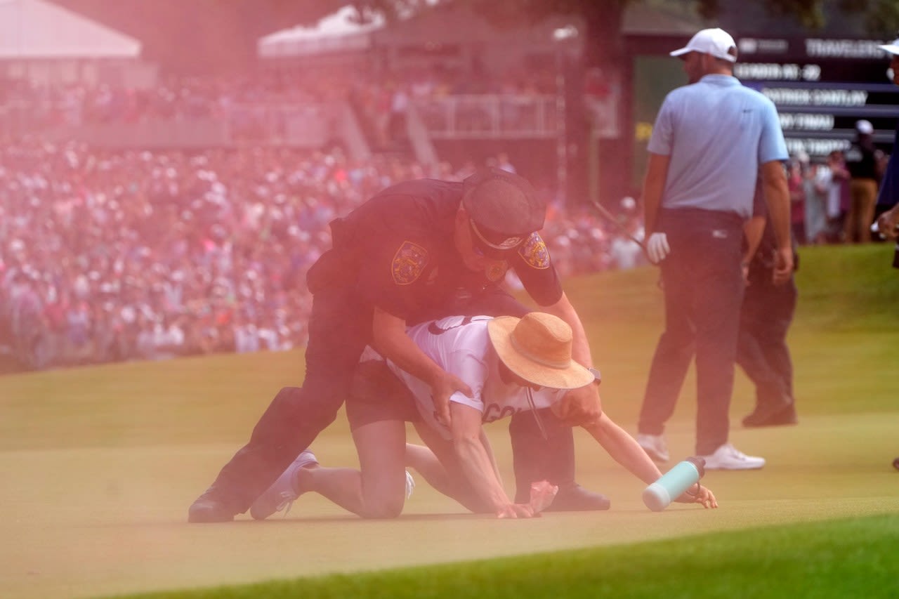 Six intruders run onto 18th green and spray powder, delaying finish of Travelers Championship