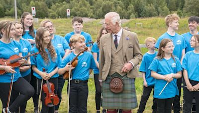 King battles midges on visit to Highland peat bog declared world heritage site