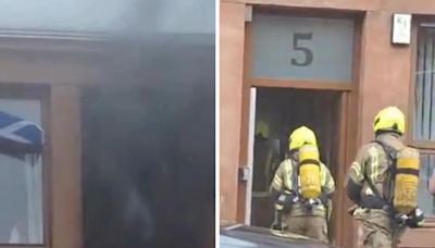 Clouds of dark smoke pour out of window as 999 crews race to tenement fire