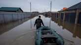 Russians flee 'very unusual' floods in boats clutching valuables, food, pets