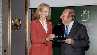 El uniforme más elegante de la Infanta Elena es con traje, camisa y el bolso Chanel que también ama la Reina Sofía