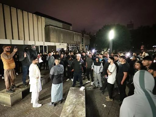 Hundreds gather outside police station as anger rises over video of officer kicking man in head at Manchester Airport