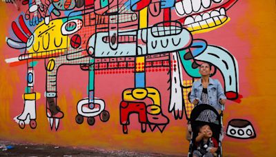 El Salvador muralists paint over traces of violence in San Salvador neighborhood