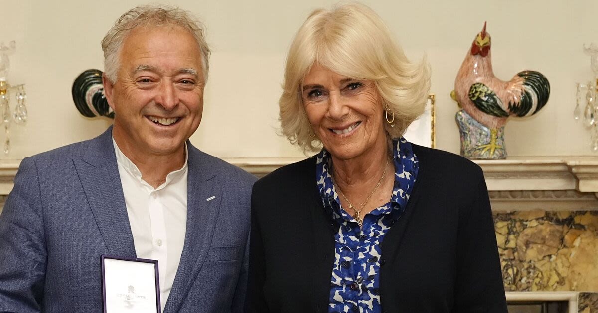 Queen Camilla wows in blue dress as she meets famous author at Clarence House