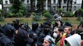 Demonstrators face law enforcement officers during a protest against the controversial "foreign influence" bill near the parliament in Tbilisi