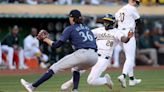 ...Cameron slides past the Seattle Mariners' Logan Gilbert to score in the fifth inning at Oakland Coliseum on Wednesday, June 5, 2024, in Oakland, California.