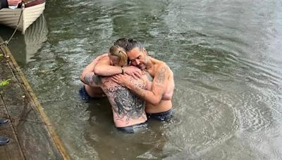 Russell Brand hugs pal Bear Grylls in the River Thames in newly released picture - after scandal-hit comic revealed he'd been baptised