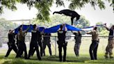 A tranquilized black bear takes a dive from a tree in Pennslyvania, falls into a waiting tarp