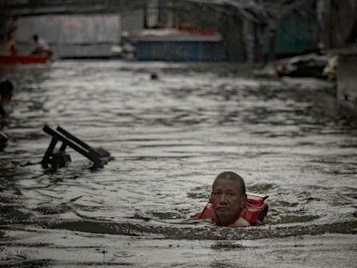 Thousands stranded by floods in Philippine capital as deadly typhoon prompts calls for climate action