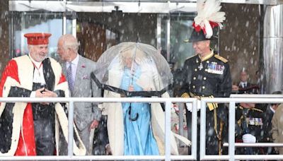 Lip reader on Charles' blunt demand as he helps struggling Camilla in harsh rain