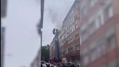 Intervención de bomberos sofocando un incendio en un piso de Gijón