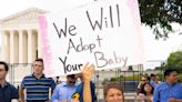 Couple’s ‘We will adopt your baby’ sign accidentally sparks hilarious memes