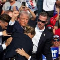 Republican candidate Donald Trump was pictured seen with blood on his face surrounded by secret service agents after the assassination bid
