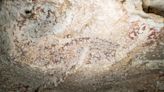 A cave drawing of two humans and a pig is the world’s oldest known narrative art