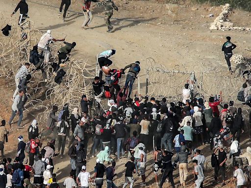 Migrants scale barbed wire fences to storm into enclave in Morocco