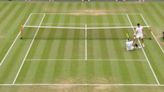 Carlos Alcaraz races around the net to help Tiafoe during Wimbledon clash