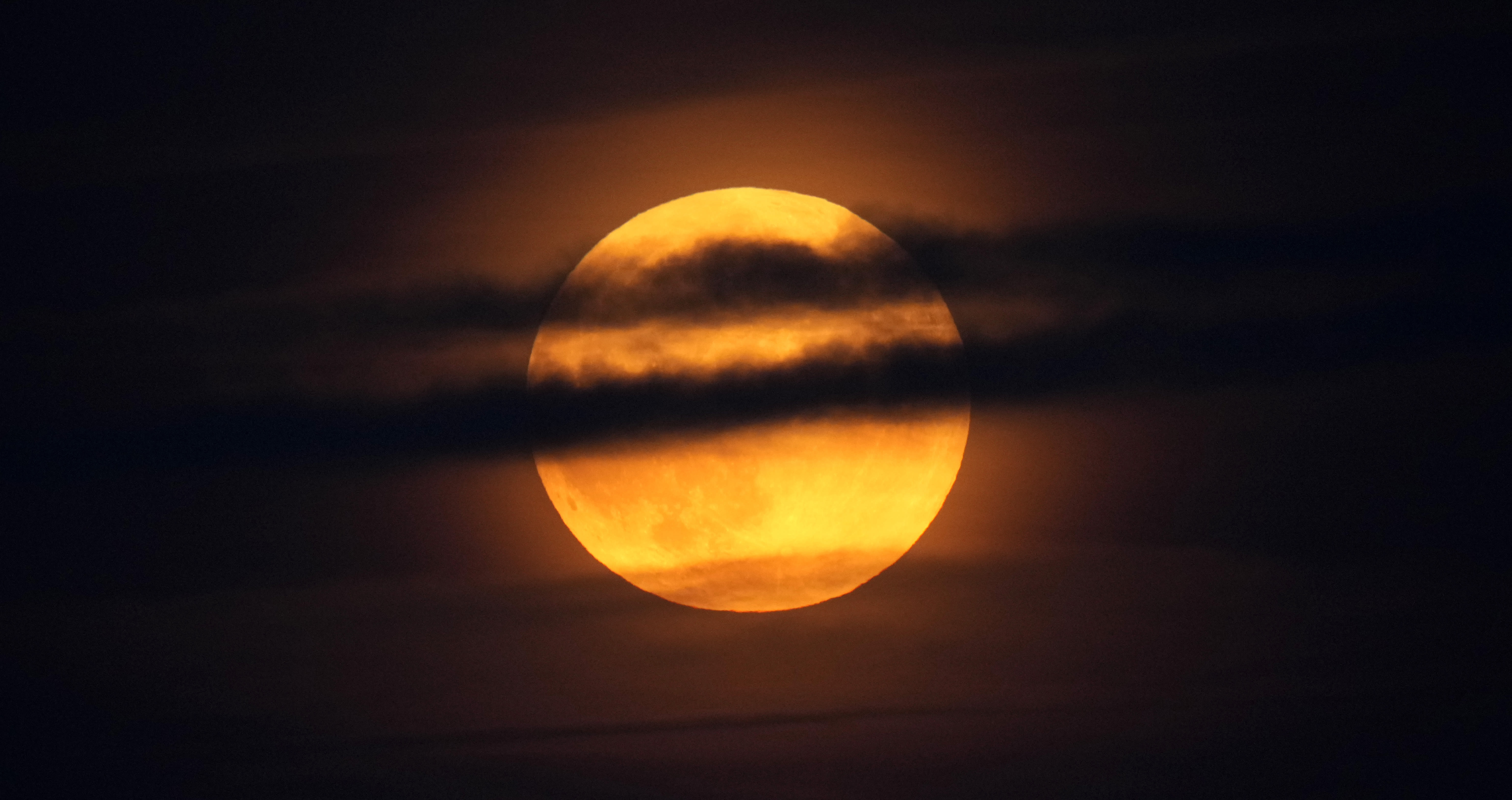 Harvest supermoon and partial lunar eclipse dazzle the night sky in rare phenomenon