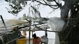 A woman stands next to her damaged house after Cyclone Remal made landfall in Bangaldesh