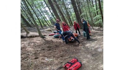 Mountain rescue team help evacuate injured mountain biker from woods