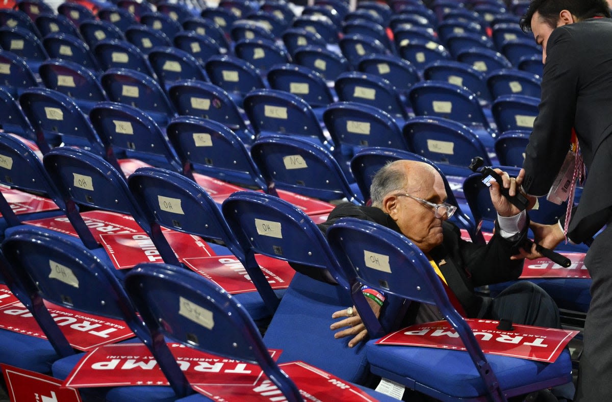 Rudy Giuliani takes a fall and tumbles into chairs while walking RNC floor