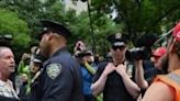 Officers separate an anti-Trump protestor (L) from a pro-Trump demonstrator (R) as people wait for a verdict in the criminal trial of the former US president on May 30, 2024