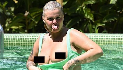 Kerry Katona flashes her bare breasts as she pulls down her bikini top