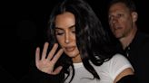 Kim covers her face at Kanye's concert as fans accuse star of 'chasing' him